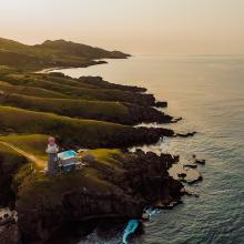 Una hermosa vista de las verdes colinas y la playa al atardecer en Batanes, Filipinas.