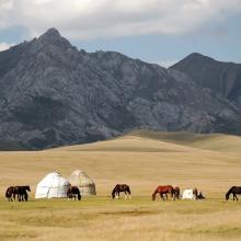 Pastores nómadas y sus venerados caballos kazajos acampan en las estepas bordeadas de montañas.