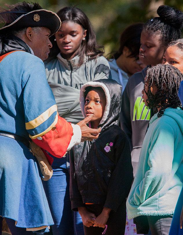Turismo sostenible: diversidad. En Fort Mose, en San Agustín, Florida, un actor da clases a un grupo de niños