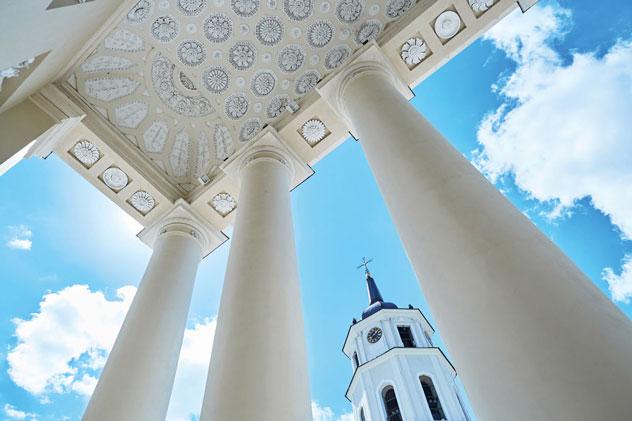 El campanario exento de la catedral de Vilna enmarcado por las columnas neoclásicas del edificio principal. Ekaterina Pokrovsky/Shutterstock ©