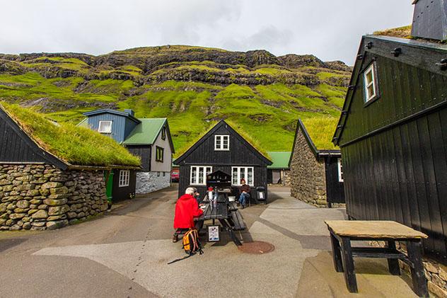 Turismo sostenible: comunidad. El puesto de gofres y café, con dos clientes, en Tjørnuvik, islas Feroe