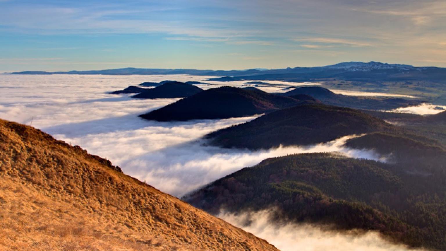 Los volcanes de Auvernia se asoman entre las nubes bajas, Francia