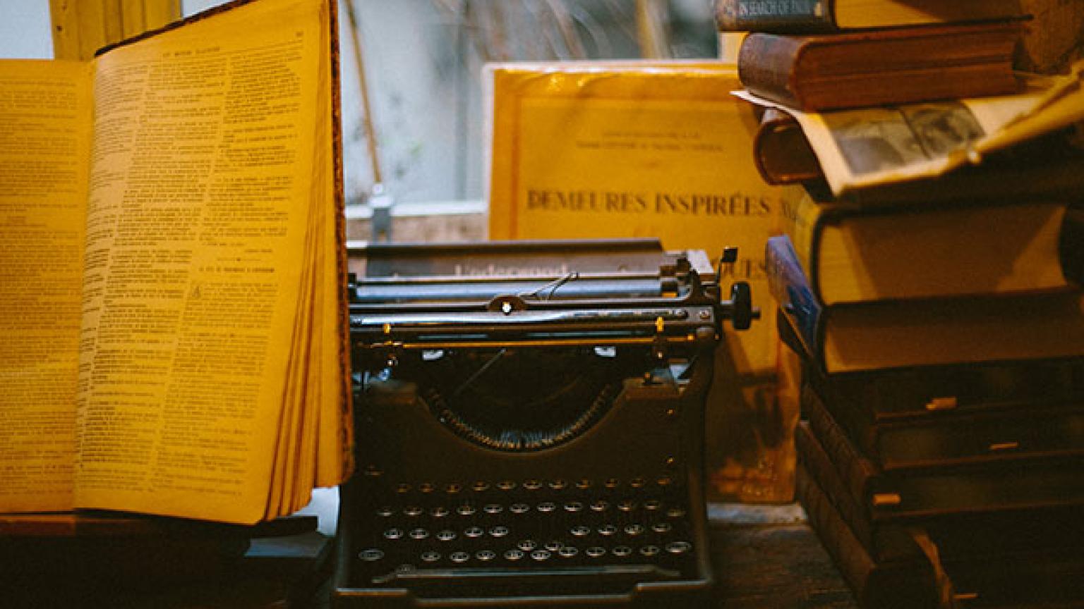 Anitgua máquina de escribir entre libros en alguna librería de París, Francia