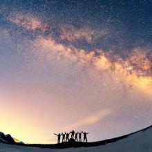 Gente celebrando la observación de la Vía Láctea, cielos oscuros