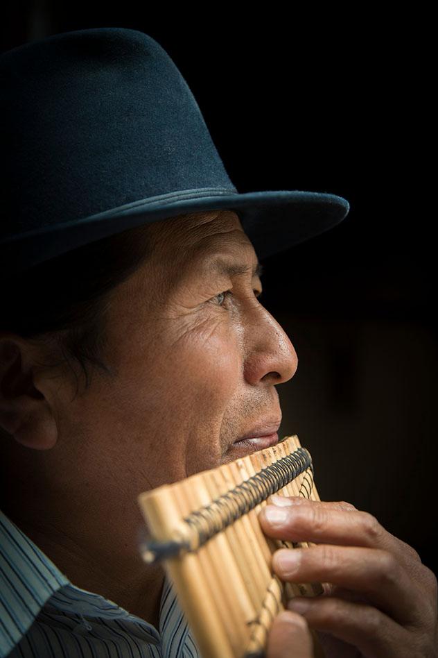 Jose Luis Fichamba toca un rondador de bambú recién fabricado en su taller, Ecuador © Philip Lee Harvey / Lonely Planet