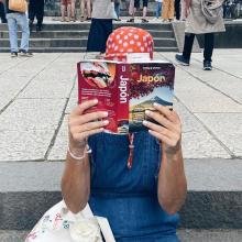 Leyendo la guía de Japón de Lonely Planet en las escaleras del templo