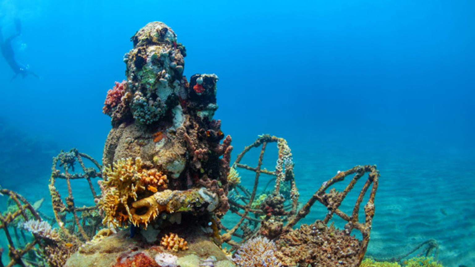 Una estatua de Buda cubierta de coral descansa en el fondo del mar, cerca de la costa de Pemuteran, Bali, Indonesia