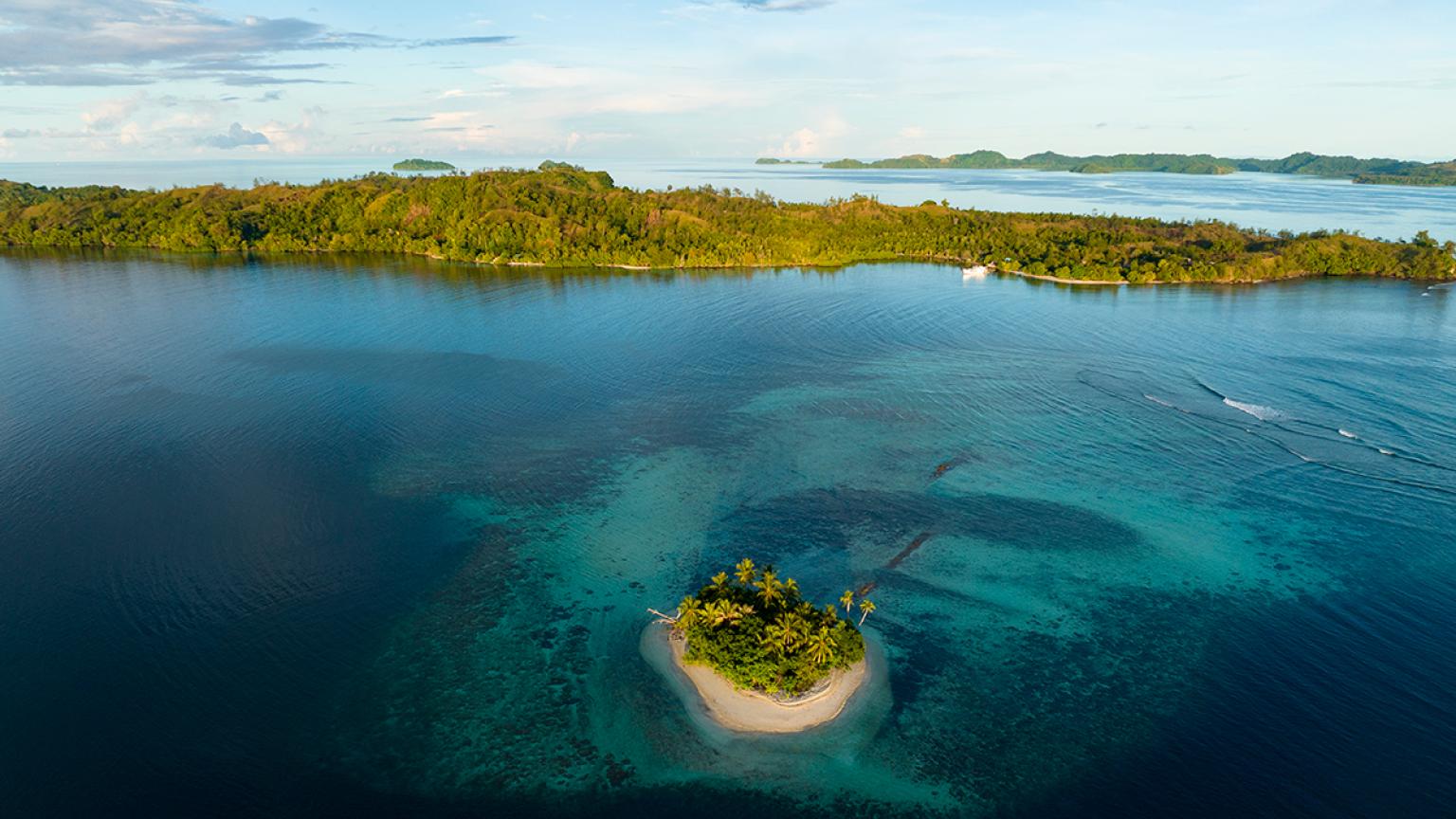 Una hermosa barrera de coral rodea una pintoresca isla en las Islas Salomón