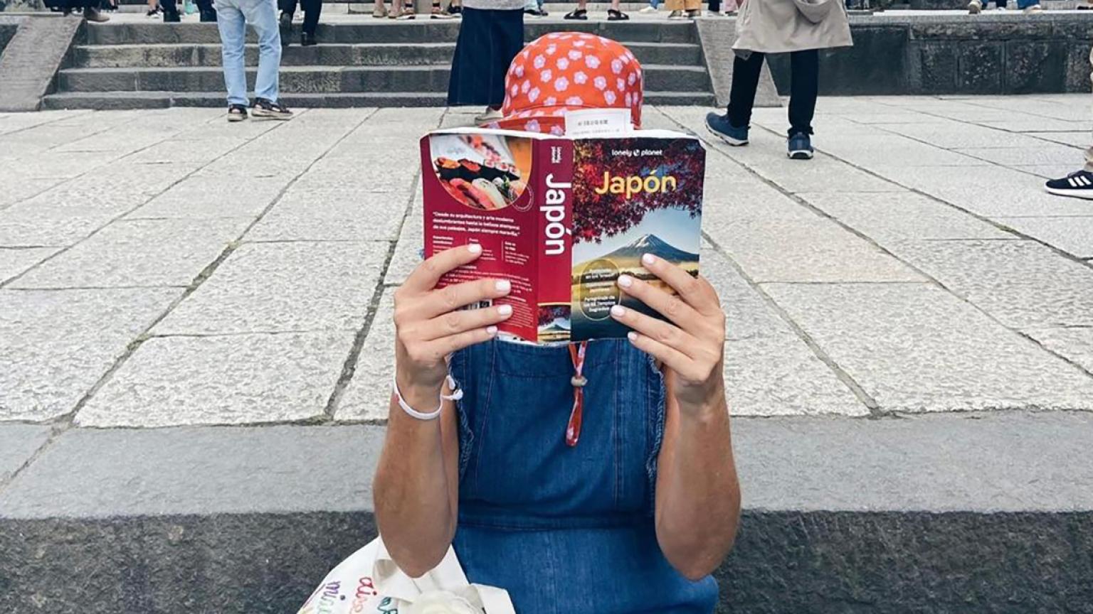 Leyendo la guía de Japón de Lonely Planet en las escaleras del templo