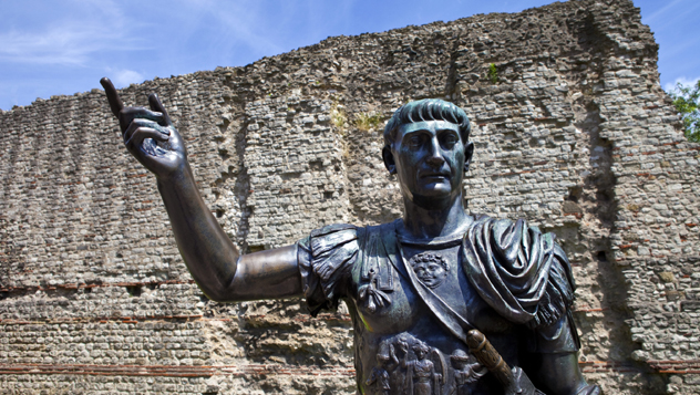 Una estatua del emperador romano Trajano monta guardia frente a los restos de la muralla de Londres © chrisdorney / Shutterstock