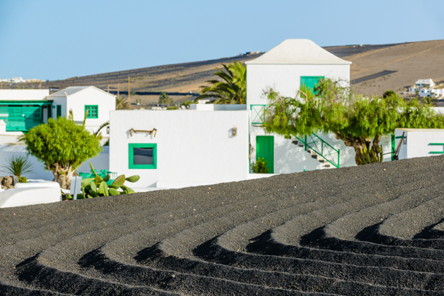 Casas encaladas contrastan sobre la tierra oscura de la isla, Lanzarote, Canarias, España © alexilena / Shutterstock