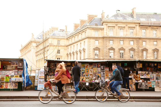 Ciclistas pedaleando frente a los Bouquinistes (vendedores de libros) de la orilla del Sena. Matt Munro/Lonely Planet