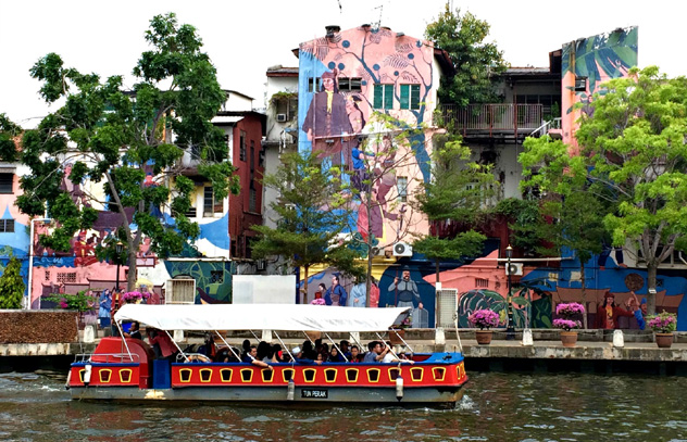 Un barco turístico surca el río Melaka ante los murales de la ribera del Melaka, Malaca, Malasia © Simon Richmond / Lonely Planet