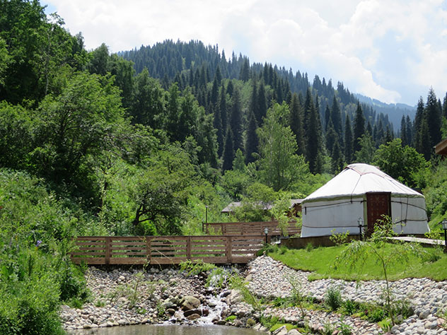 Turismo sostenible: comunidad. Una yurta (ger) y el río en los montes que rodean Almaty, Kazajistán