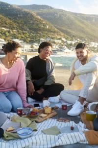 Grupo de amigos comiendo en la playa, Sudáfrica