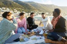 Grupo de amigos comiendo en la playa, Sudáfrica