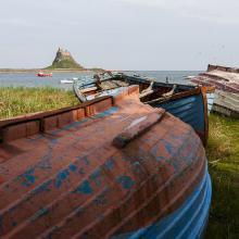 Barcos de pesca se alinean en la orilla cerca del castillo de Lindisfarne.