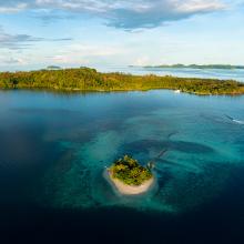 Una hermosa barrera de coral rodea una pintoresca isla en las Islas Salomón