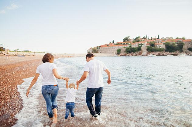 Familia viajera disfrutando de la costa © shevtsovy / Shutterstock